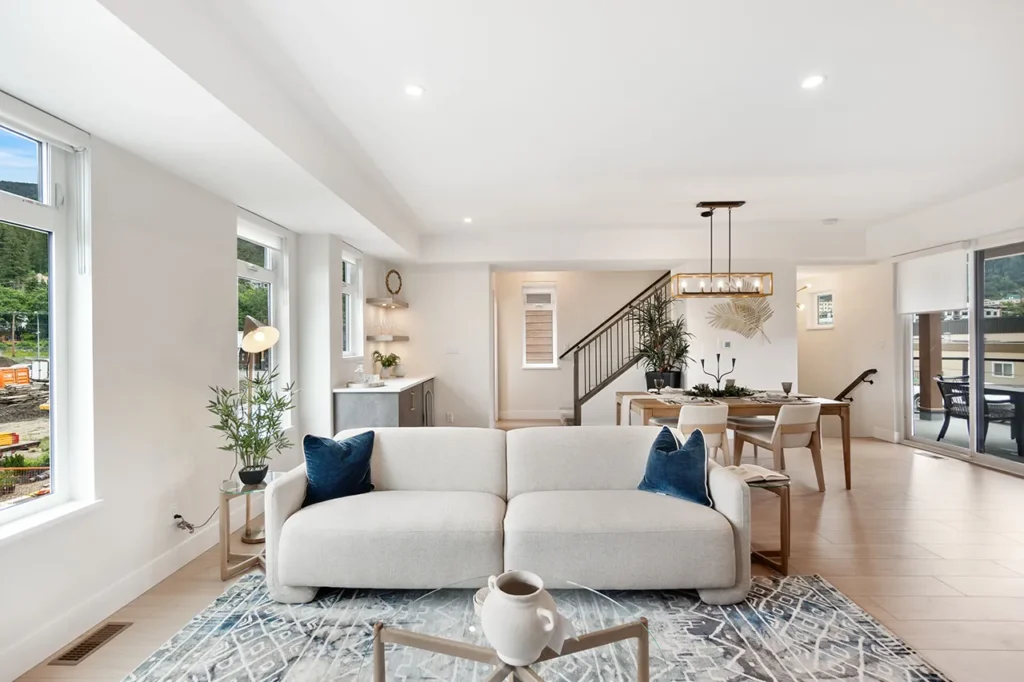 Living room showing the seating and dining areas, staircase, and outside deck